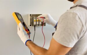 分電盤のブレーカーを測定器で確かめる電気工事士の手元