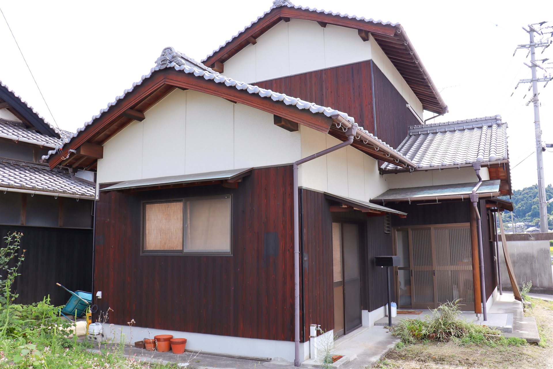 瓦屋根と板張りの壁の木造2階建ての家の外観