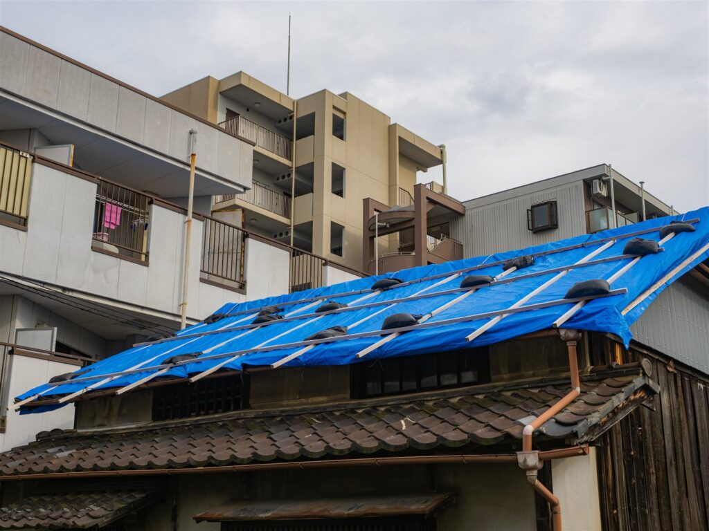 ブルーシートで覆った住宅の瓦屋根