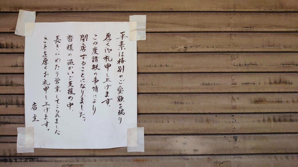 シャッターに貼られた手書きの閉店のお知らせ