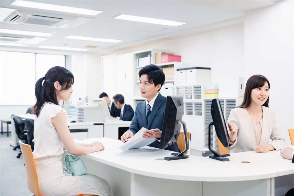窓口で来訪者に説明する職員