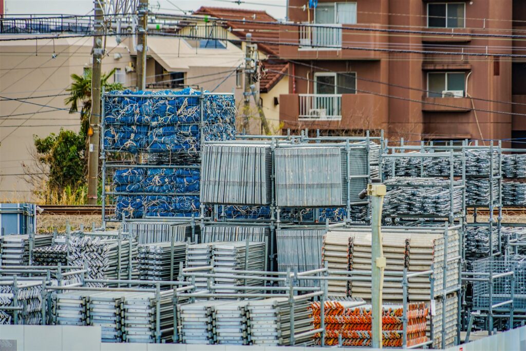住宅地の横に積まれた足場の部材と資材
