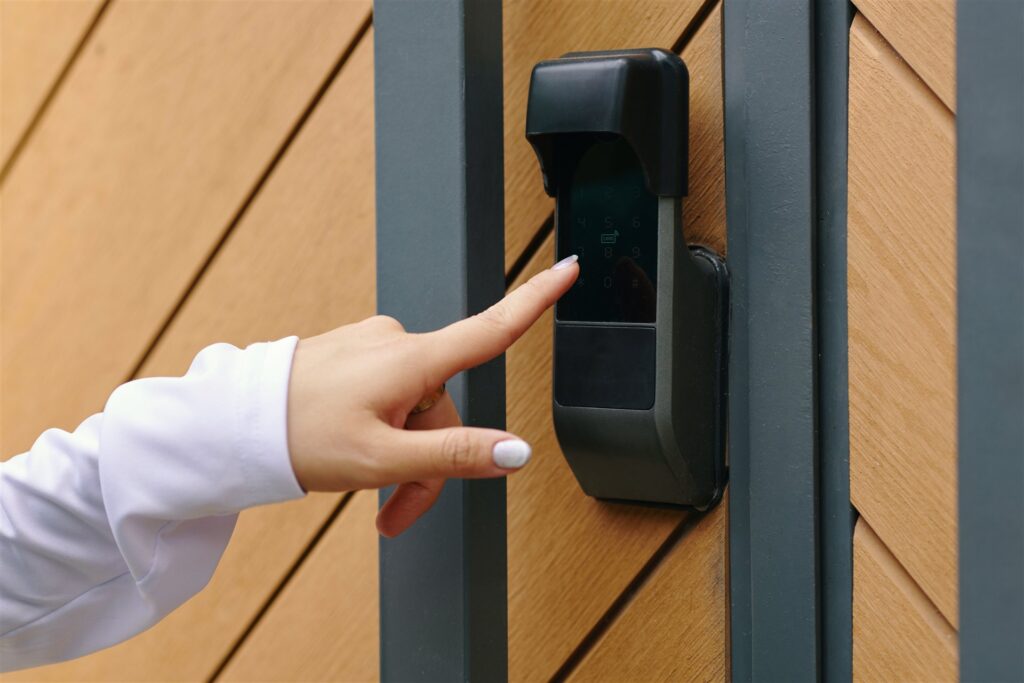 木目の扉に付いた電子錠の番号を指で押す手元