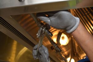 手袋をして配管を工具で締める水道工事の作業員