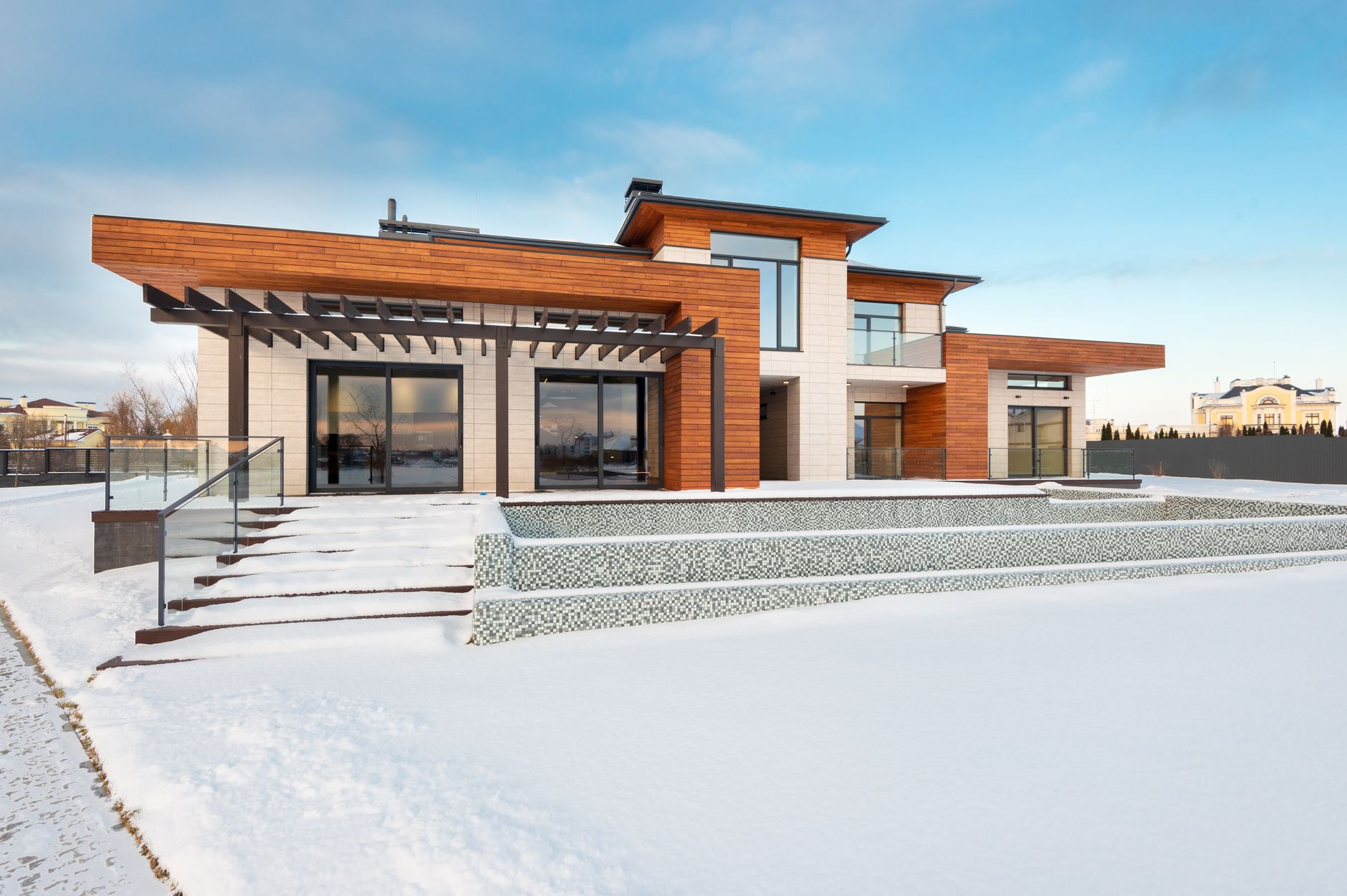 雪の中に建つ大きな窓のある新しい住宅