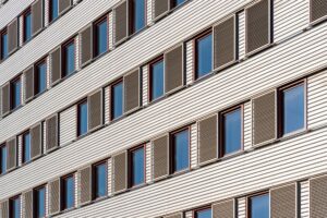 窓とよろい戸が規則正しく並ぶ建物の外壁