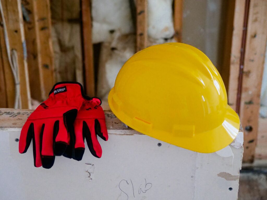 改修中の壁に置かれたヘルメットと作業手袋