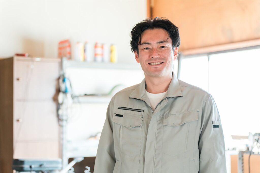 作業場に立つ作業着姿の男性