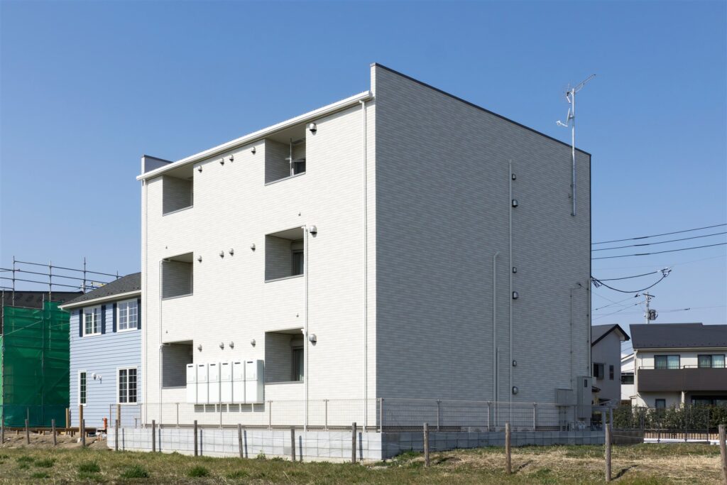 白い外壁の3階建ての建物の外観