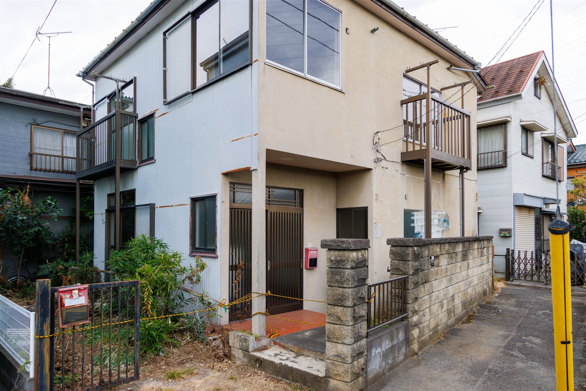 入口にロープが張られた2階建ての空き家