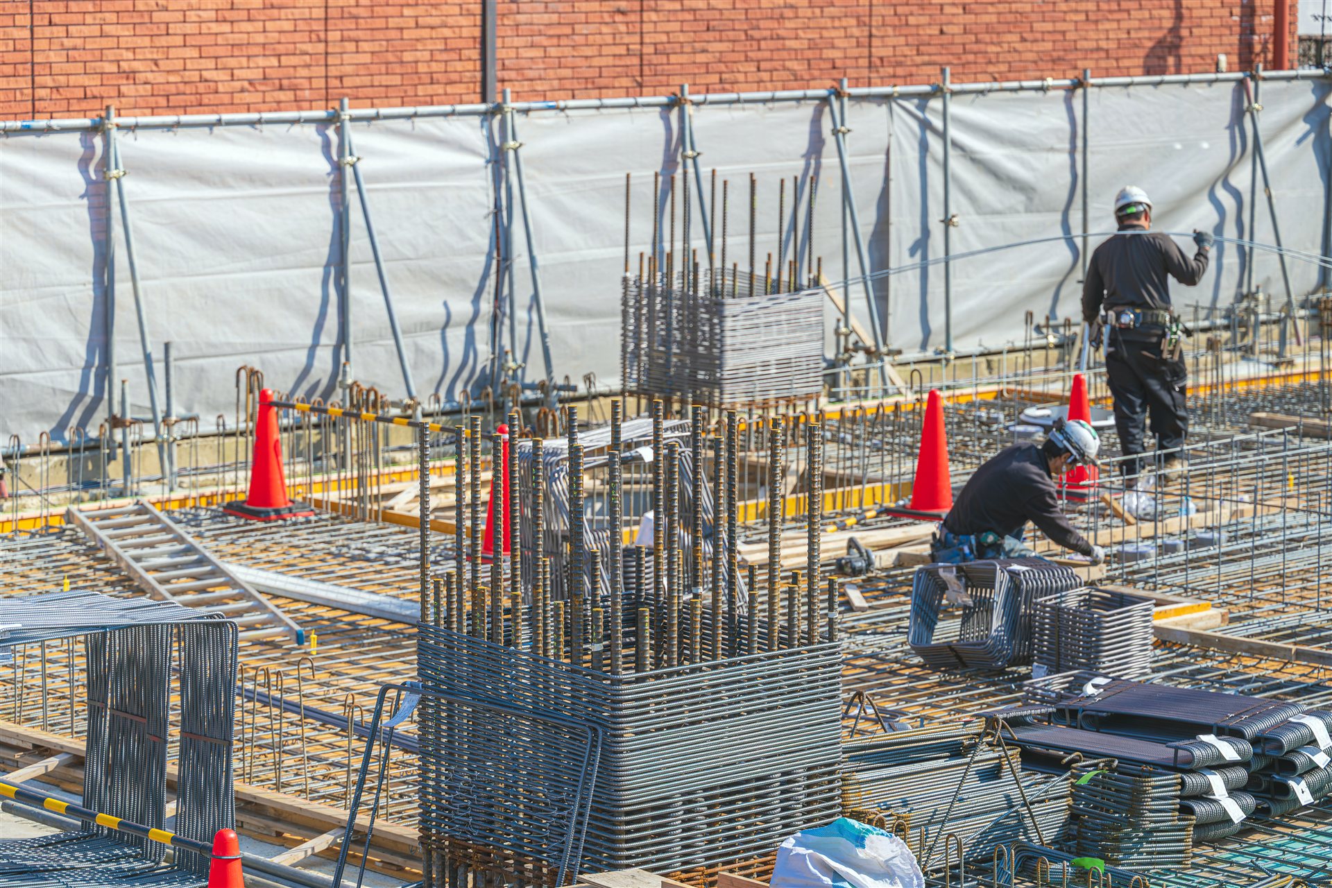 鉄筋を組む建設現場で作業する職人たち