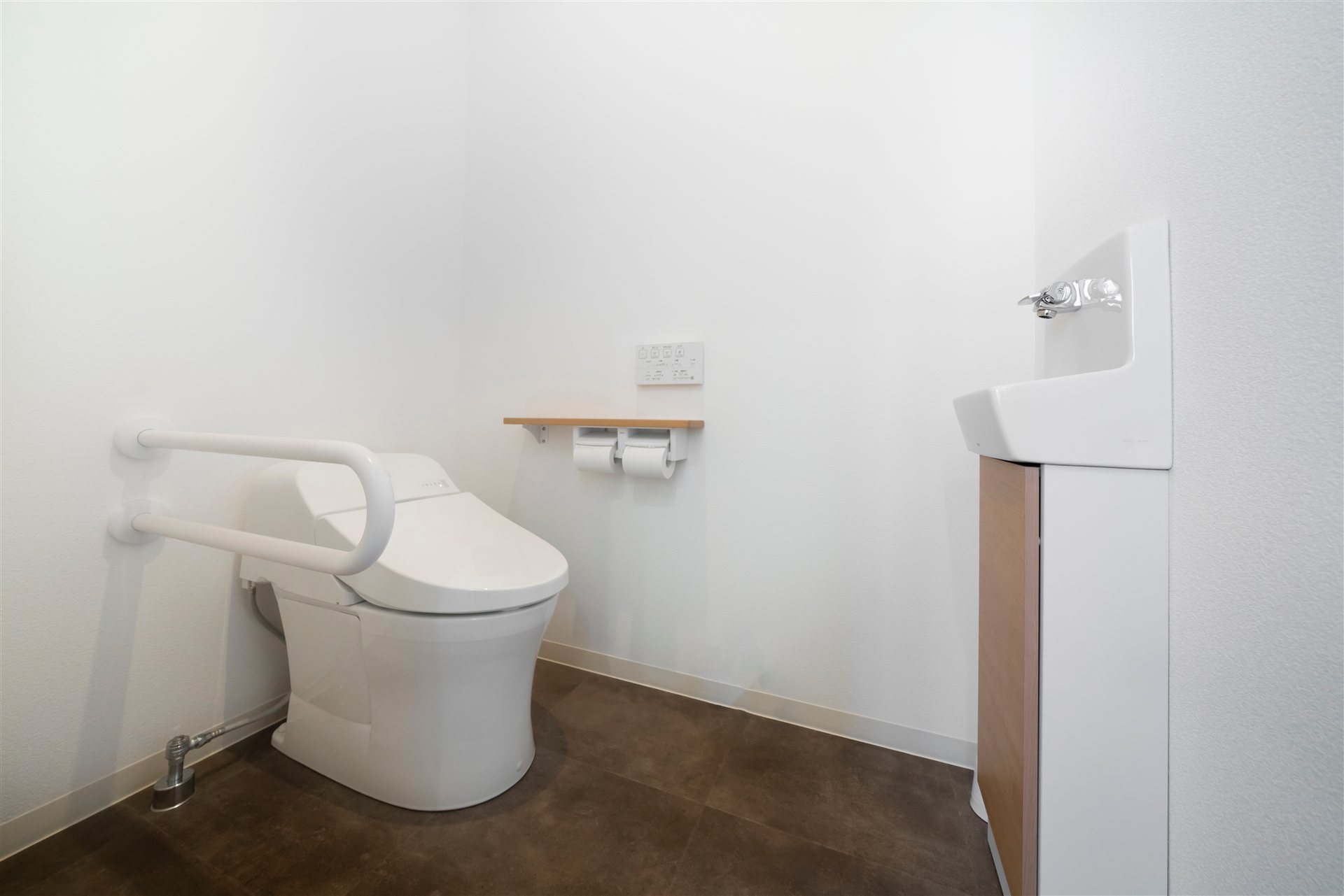 洋式トイレの横の壁に付けた跳ね上げ式の手すり