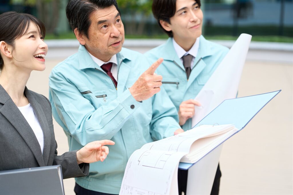 図面を広げて確認する建設会社の3人