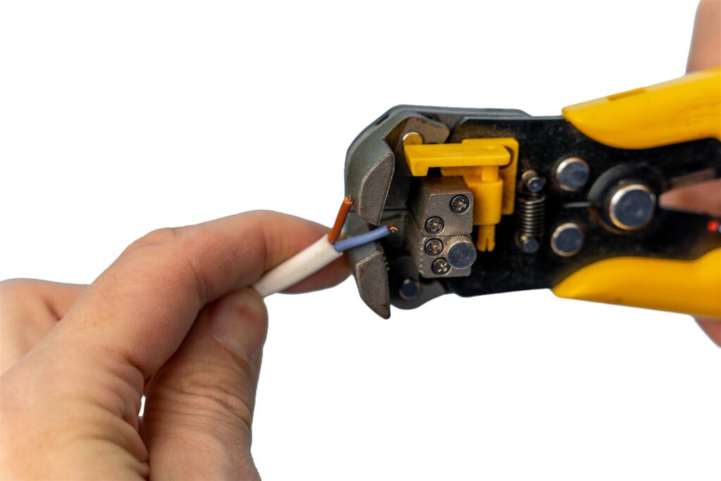 電線の被覆を工具でむく手元