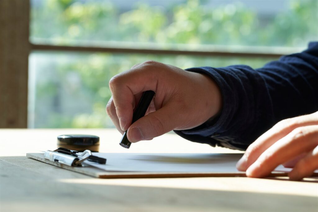 書類に印鑑を押す手元とクリップボード