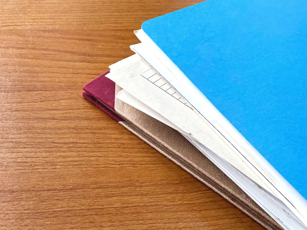木の机の上の青いファイルと書類