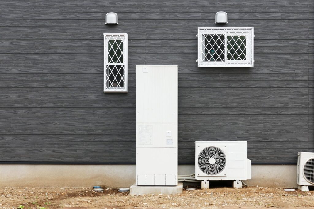 家の外壁の前のエコキュートと室外機